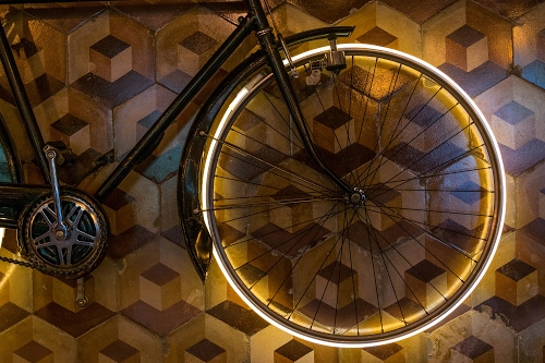 Immagine con ruota, raggi, bicicletta, pedali, luce, parafango, dinamo, cerchio, telaio, bici, catena, nero, pavimento, cubi, neon, parete