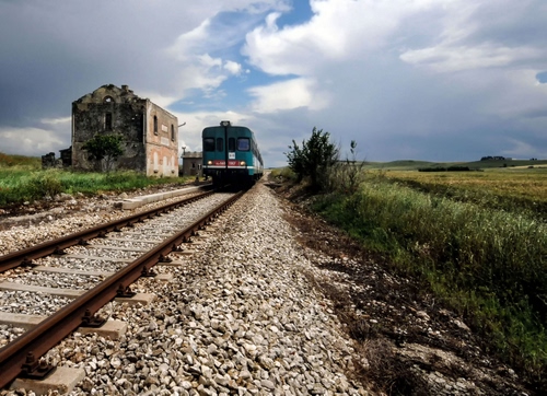 Immagine con treno, nuvole, cielo, rotaie, binario, stazione, rudere, binari, verde, erba, ferrovia, sassi, campi, traversine, metallo, massicciata