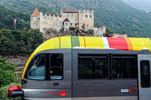 Immagine con castello, treno, giallo, montagna, alberi, colori, locomotiva, finestrini
