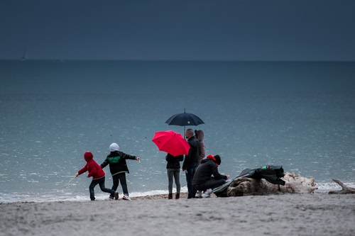 Immagine con ombrelli, mare, bambini, spiaggia, persone, rosso, sabbia, orizzonte, pioggia, acqua, cielo, inverno, onde, due, maltempo