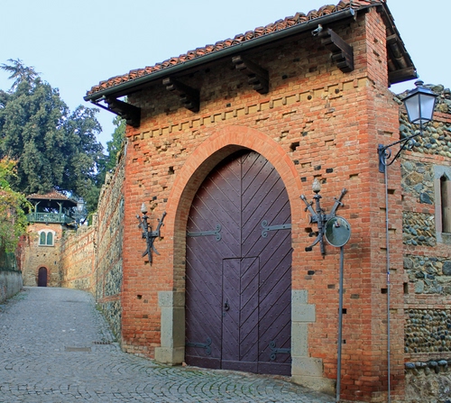 Immagine con portone, alberi, lampione, mattoni, castello, specchio, cielo, tetto, muro, strada, porta, tegole, mura, lampioni, finestre, torre, spade, legno, arco, tettoia