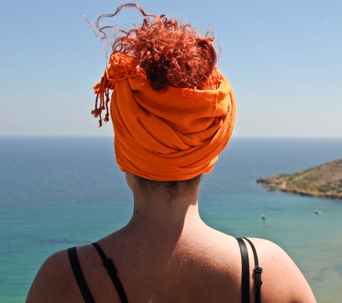 Immagine con mare, capelli, arancione, donna, spalle, turbante, cielo, ricci, schiena, arancio, asciugamano, bretelle, rossi, rosso, spalline, copricapo, testa