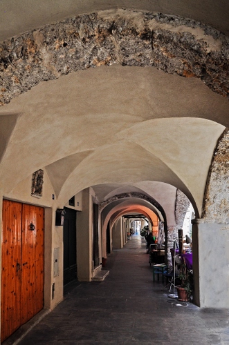 Immagine con portico, archi, porta, portone, prospettiva, volta, volte, vaso, colonne, sedie