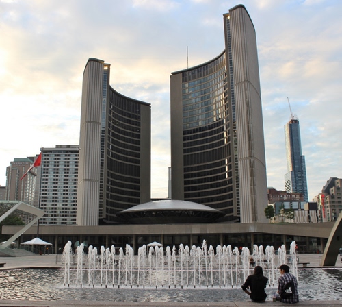 Immagine con grattacieli, fontana, acqua, persone, zampilli, palazzi, cielo, finestre, due, bandiera, città, architettura