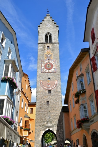 Immagine con orologio, torre, meridiana, case, stemma, bifora, arco, vipiteno, cielo, finestre, campanile