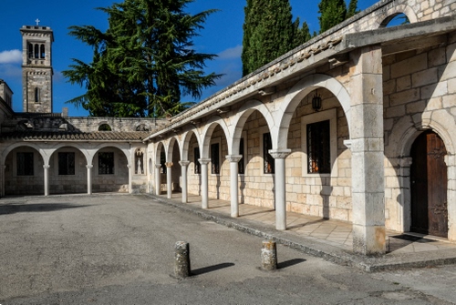 Immagine con campanile, alberi, archi, chiesa, portici, colonne, portico, porticato, colonnato