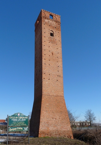 Immagine con torre, cielo, alberi, finestre, mattoni, cartello, verde, azzurro, piante, erba, piemonte, inverno, case, insegna, carignano