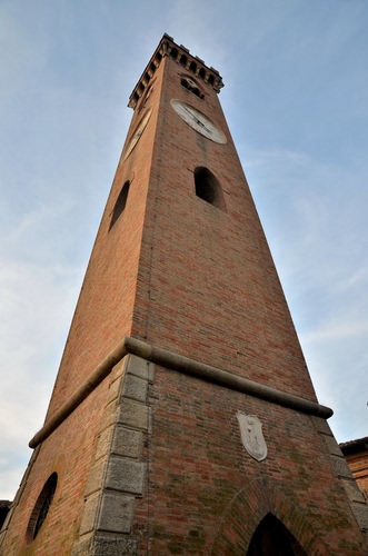 Immagine con torre, orologio, stemma, cielo, finestre, prospettiva, merli, finestra, mattoni, campanile