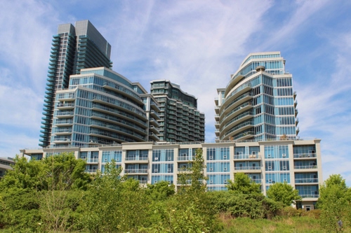 Immagine con alberi, palazzi, verde, grattacielo, cielo, grattacieli, finestre, nuvole, vetri, azzurro, vetrate