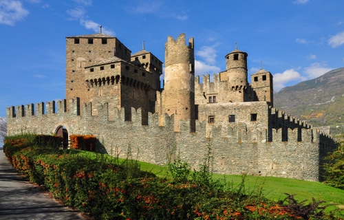 Immagine con castello, torri, merli, siepe, mura, medioevo, prato, cielo, fortezza