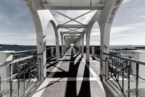 Immagine con ponte, prospettiva, ombre, archi, mare, ombra, cielo, ringhiera, bianconero