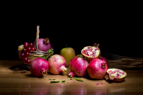 Immagine con frutta, melograni, uva, melograno, mela, cesto, tavolo, natura, rosso, cestino, cibo, riflesso