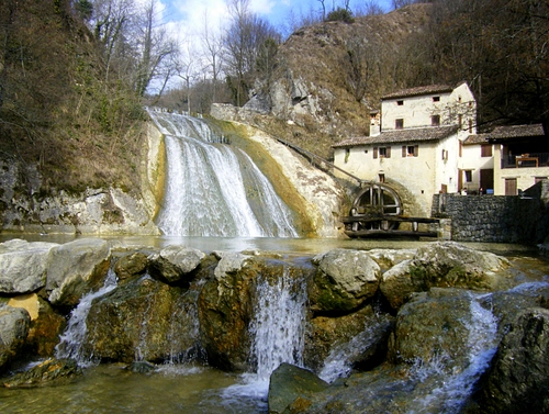 Immagine con mulino, cascata, acqua, fiume, ruota, rocce, alberi, casa