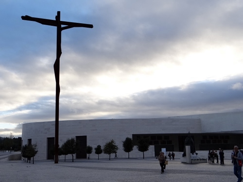 Immagine con croce, cielo, alberi, nuvole, chiesa, persone, piazza, crocifisso, bianco