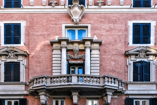 Immagine con balcone, finestre, stemma, colonne, palazzo, facciata, rosa, persiane