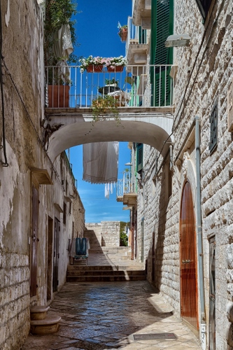 Immagine con vicolo, balcone, arco, cielo, gradini, porta, vasi, fiori, scalini, porte, ringhiera, ponte, biancheria