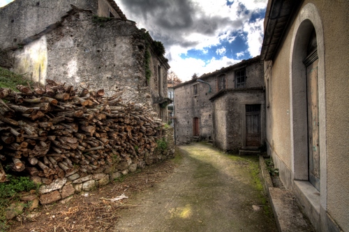 Immagine con legna, vicolo, nuvole, porte, cielo, strada, catasta, scorcio