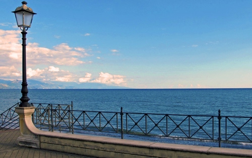 Immagine con mare, lampione, ringhiera, nuvole, cielo, acqua, orizzonte, azzurro, blu, lungomare