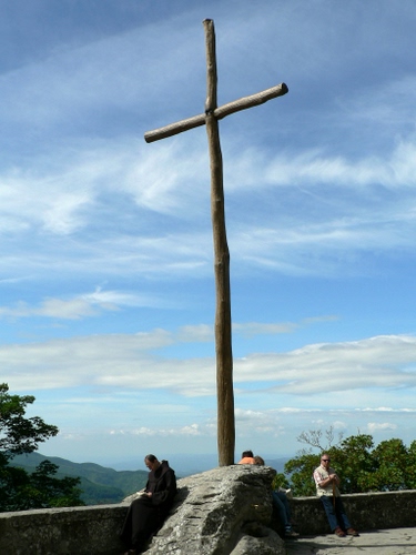 Immagine con croce, cielo, legno, nuvole, persone, montagna, frate, panorama, roccia, alberi