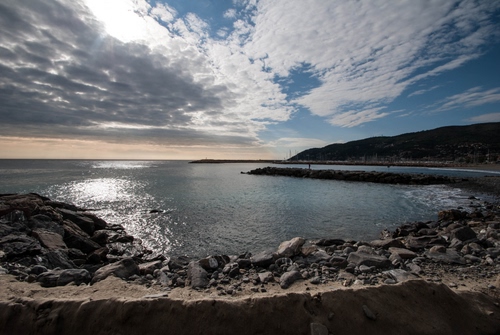 Immagine con nuvole, mare, scogli, acqua, pietre, sassi, controluce, panorama, cielo, molo