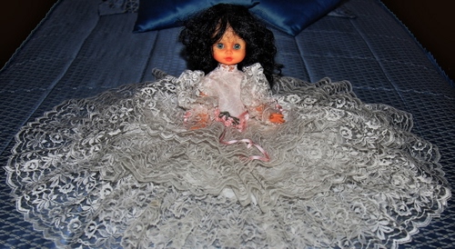 Immagine con bambola, vestito, bianco, letto, pizzo, giocattolo, capelli, abito, viso, cuscini