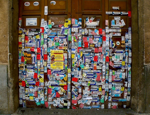 Immagine con adesivi, portone, porta, legno, colori, pubblicità, etichette, locandina, rosso, tanti, multicolore, biglietti