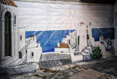 Immagine con bianco, murales, sole, azzurro, muro, barche, case, strada, dipinto, porta, mare, scale, tetti, finestre, murale