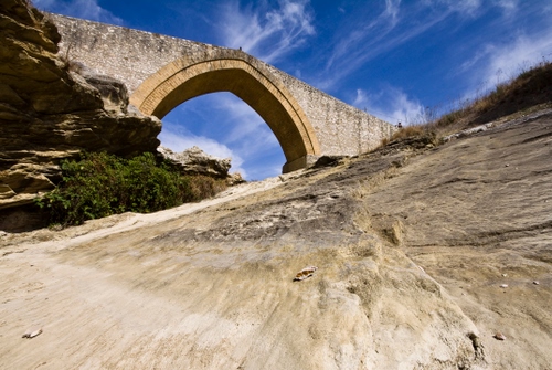 Immagine con ponte, cielo, arco, nuvole, roccia, pietre, rocce
