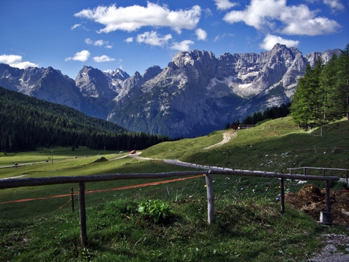 Immagine con alberi, montagne, nuvole, staccionata, panorama, montagna, prati, verde, cielo
