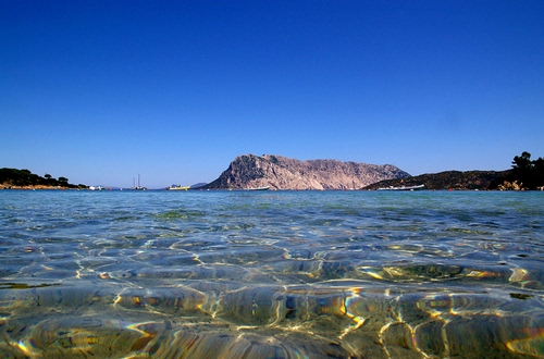 Immagine con mare, acqua, riflessi, isola, cielo, onde, barche, montagna, limpida, azzurro