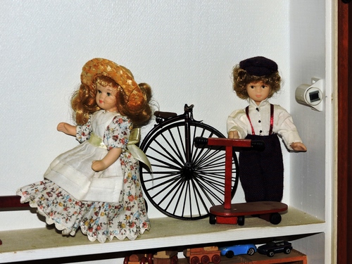 Immagine con bambole, bicicletta, giocattoli, ruota, monopattino, giocattolo, mensola, bianco