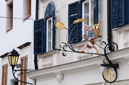 Immagine con lampione, insegna, finestre, persiane, spiga, blu, fornaio