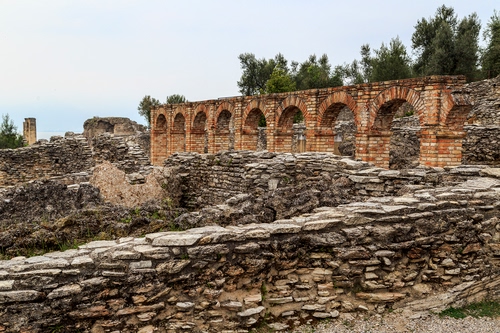 Immagine con archi, ruderi, rovine, alberi, pietre, mattoni, acquedotto, cielo
