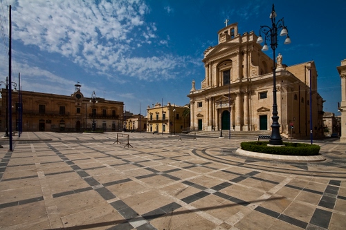 Immagine con chiesa, piazza, lampioni, nuvole, lampione, cielo, geometrie