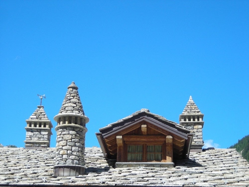 Immagine con tetto, abbaino, cielo, comignoli, finestra, tegole, pietre