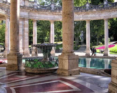 Immagine con fontana, colonne, acqua, giardino, alberi, verde, pavimento, fiori, geometrie, marmo, vasca, persone, capitelli, riflesso