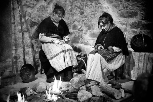 Immagine con donne, fuoco, bianconero, due, legna, grembiuli, pietre, padella, lavoro, vestiti, sassi