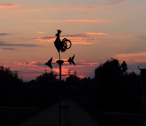 Immagine con tramonto, gallo, freccia, controluce, nuvole, banderuola, nero, rosso, cardinali