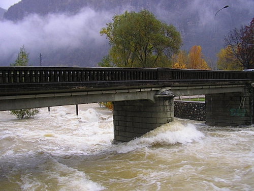 Immagine con fiume, ponte, alberi, acqua, nuvole, piena, maltempo