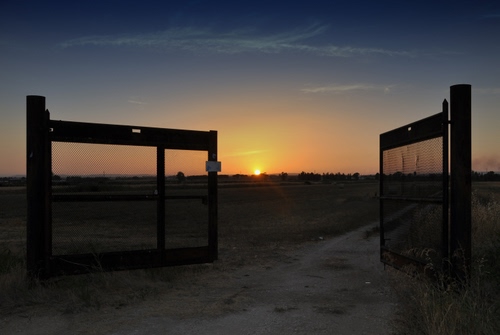Immagine con cancello, tramonto, sole, strada, aperto, cielo, controluce