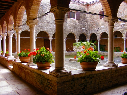 Immagine con colonne, chiostro, vasi, fiori, portico, archi, pozzo, piante