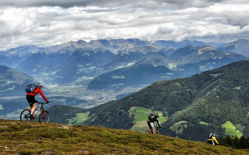 Immagine con nuvole, montagne, panorama, ciclisti, biciclette, verde, cielo, monti, zaino, paesaggio, boschi, montagna, valle, sport, prato, zaini, bicicletta, alberi