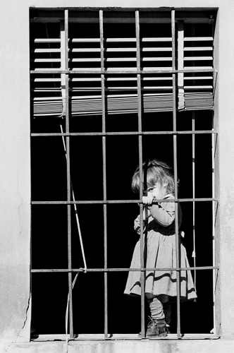 Immagine con bambina, finestra, bianconero, inferriata, grata, mano, corda, veneziana, nero, vestito, rettangoli, tapparella, tenda, capelli