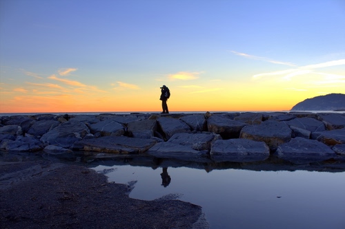 Immagine con riflesso, acqua, fotografo, tramonto, mare, massi, cielo, uomo, controluce