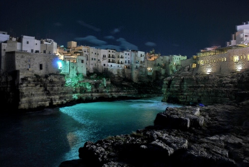 Immagine con mare, notte, case, acqua, luci, notturno, borgo, cielo, scogli, scogliera