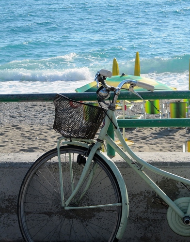 Immagine con mare, bicicletta, cestino, ruota, ombrelloni, spiaggia, sabbia, manubrio, ringhiera, sdraio, acqua, onda, onde, ombrellone, verde, raggi