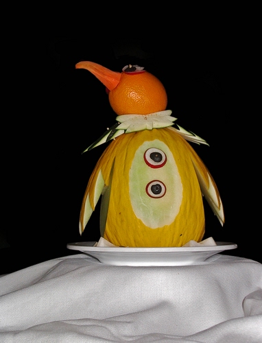 Immagine con piatto, melone, pinguino, bianco, giallo, arancio, tovaglia, frutta, arancia, arancione, carota, animale