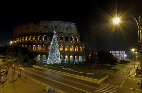 Immagine con colosseo, albero, notte, natale, luci, lampione, roma, archi, strada, lampioni, alberi, strade, piazza, luce, strisce, aiuola, notturno