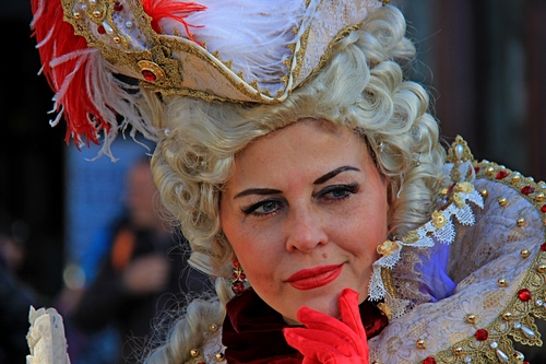 Immagine con rosso, carnevale, piume, cappello, donna, parrucca, maschera, trucco, guanto, ritratto, perle, bianco, sguardo, occhi, viso, ciglia, costume, capelli, labbra