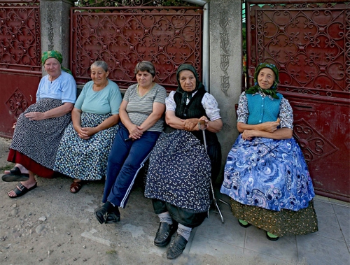 Immagine con donne, cinque, grembiuli, sedute, contadine, anziane, cancelli, gonne